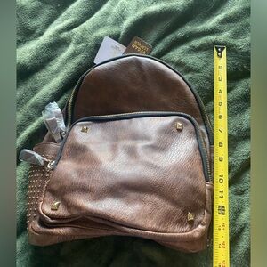 Women’s brown backpack purse with gold studs and accents